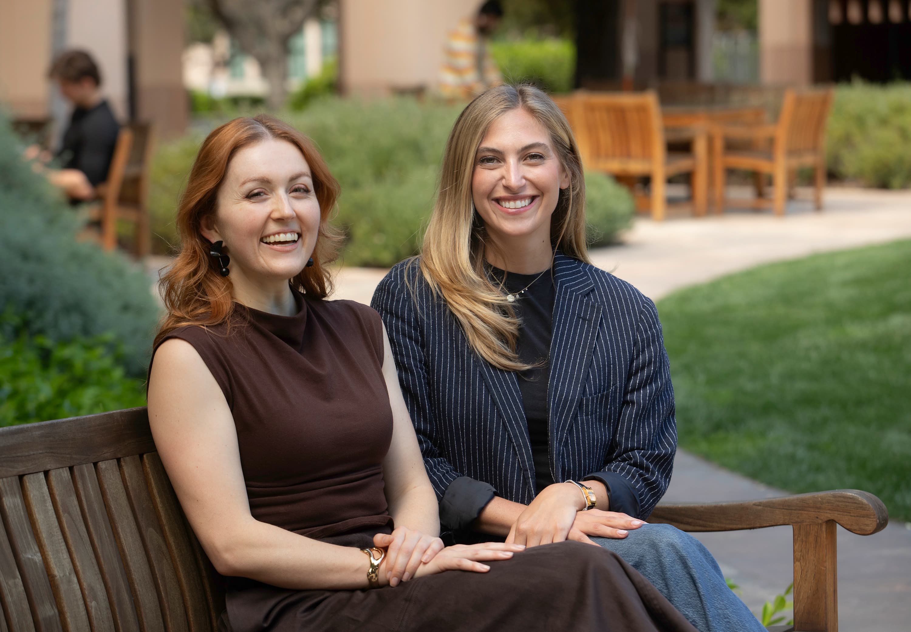 Celeste Bean and Jenni Steiger seated on a bench outdoors